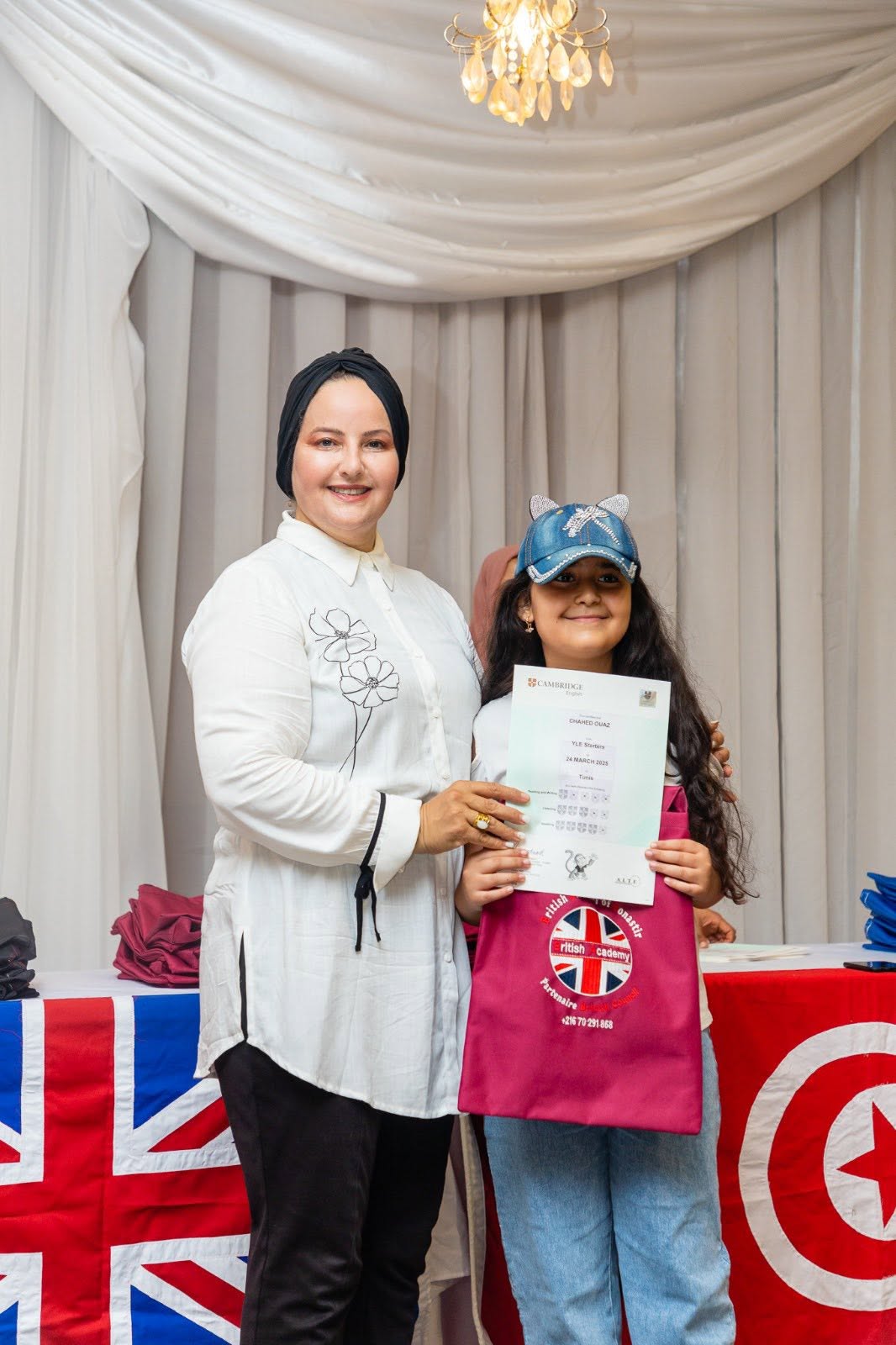 Student holding her Cambridge English YLE certificate