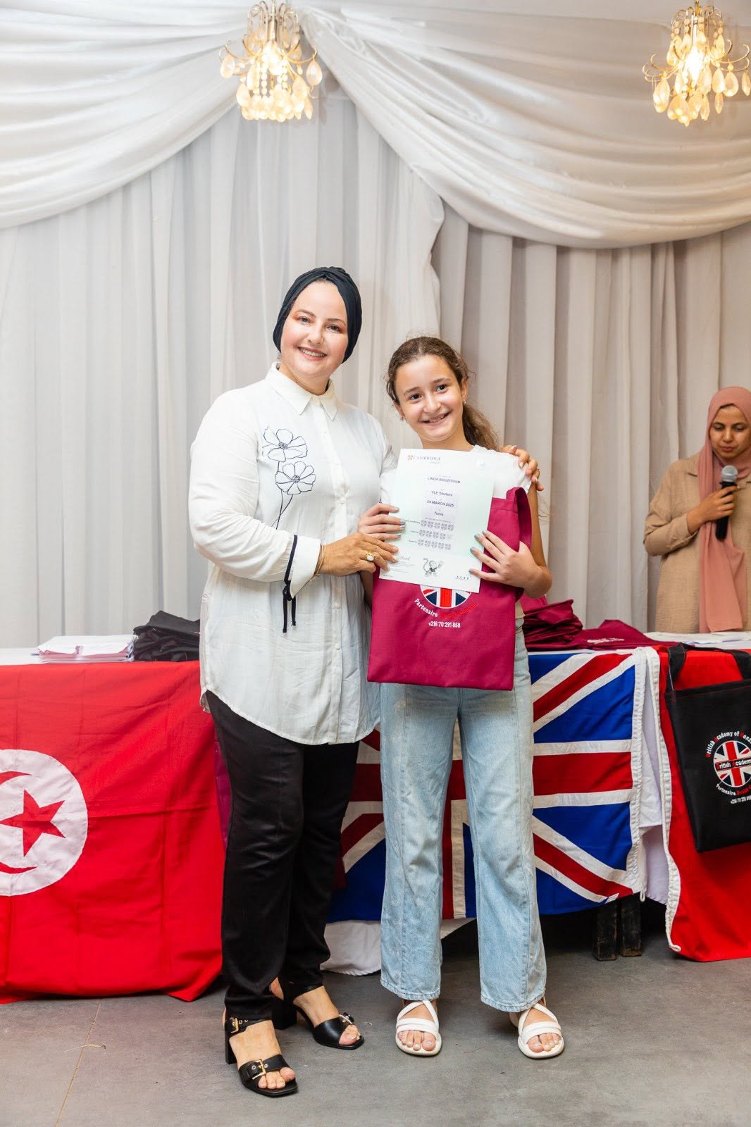 Student holding her Cambridge English YLE certificate
