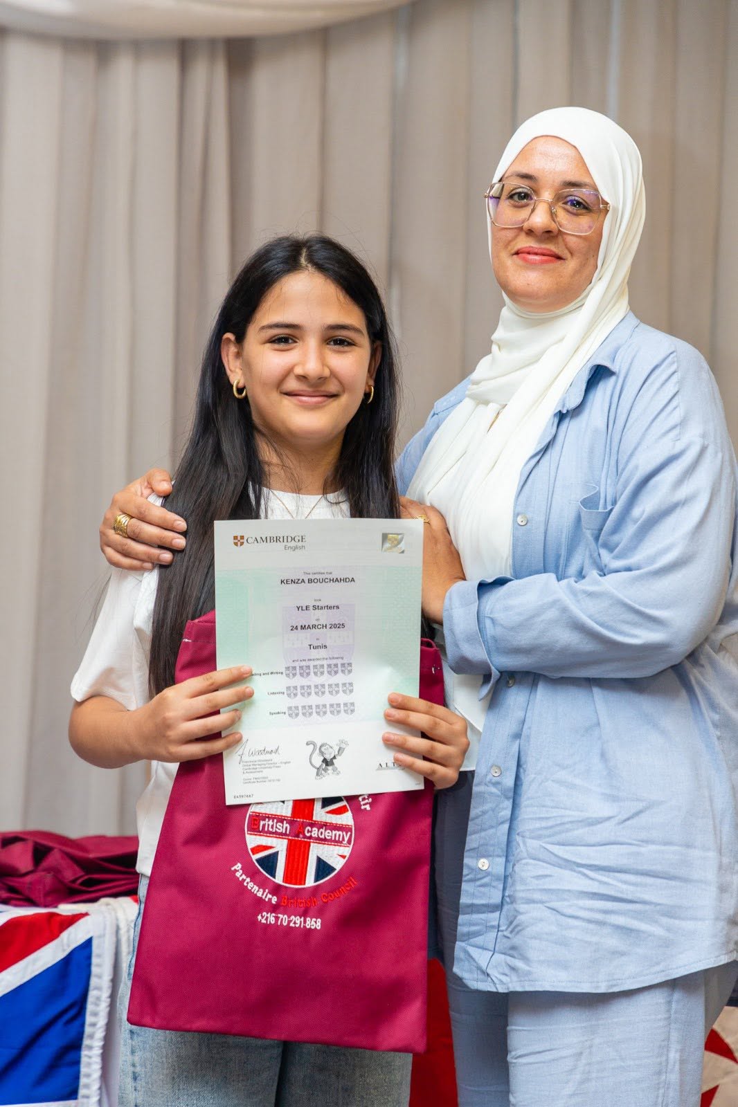 Student and her mother holding her Cambridge English YLE certificate
