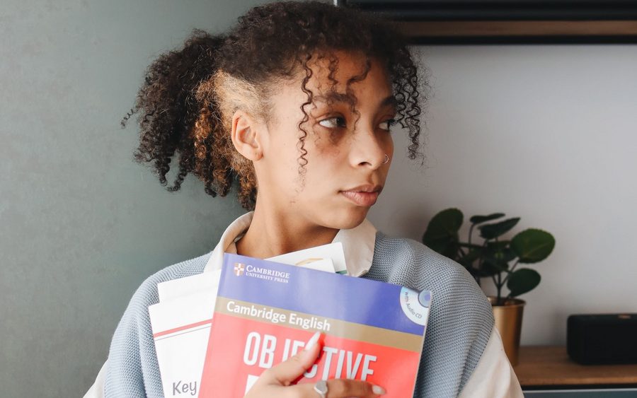 Adult student holding Cambridge English course books